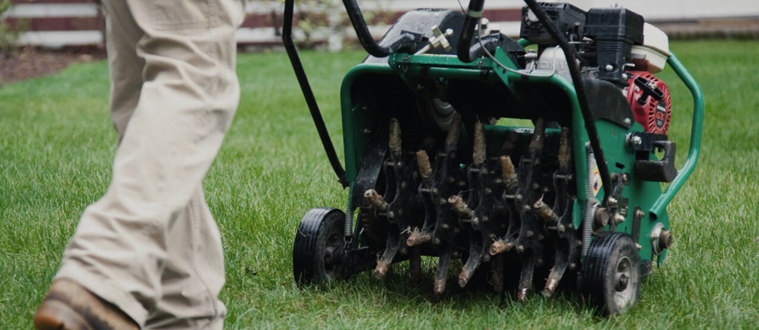 Core aeration service with machine on residential lawn